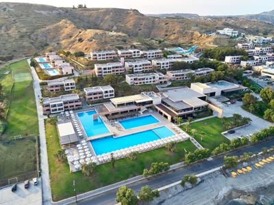 Veduta aerea di un hotel con più edifici e una grande piscina in un paesaggio collinare.