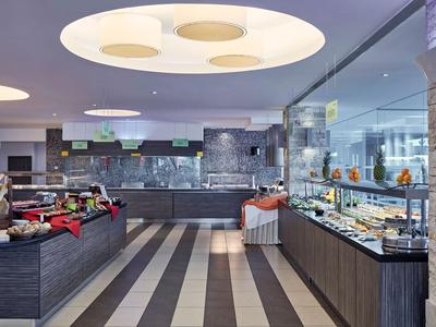 Buffet moderno in un'area pranzo elegante con vari piatti e illuminazione luminosa.