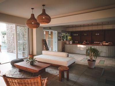 Moderner Hotel-Loungeraum mit Sitzgelegenheiten, Holzmöbeln und großer Glasfront.