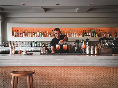 Bartender bereitet bunte Cocktails an einer modernen Bar in einem Hotel vor.