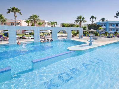 Groot zwembad met blauwe gevel en witte bogen met palmbomen op de achtergrond