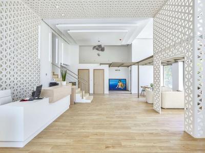 Moderne, helle Hotellobby mit weißen Wandelementen und Holzfußboden.