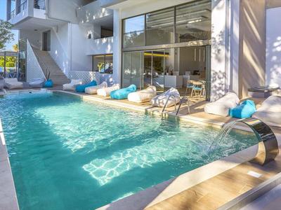 Moderner Außenpoolbereich mit Liegestühlen und Glastüren in einem Hotel