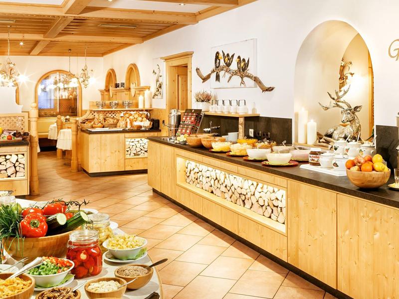 Warm, spacious buffet area with wooden decor and a variety of fresh foods and fruits.