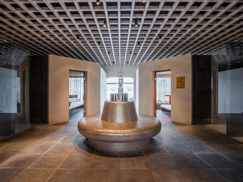 Modernes Hotel-Lobby mit rundem Sitzbereich und beleuchtetem zentralem Brunnen