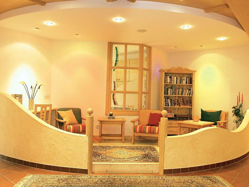 Cozy hotel lounge area with sofas, carpet, and warm lighting.