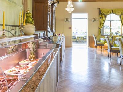 Buffet mit frischen Früchten und Speisen in einem elegant eingerichteten Speisesaal eines Hotels.