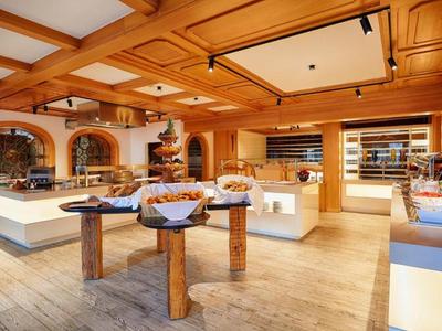 Bright shop with wooden ceiling, displays, and various baked goods on tables and shelves.