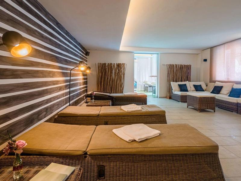 Inviting wellness area with loungers, wall lamps, and large windows for natural light.
