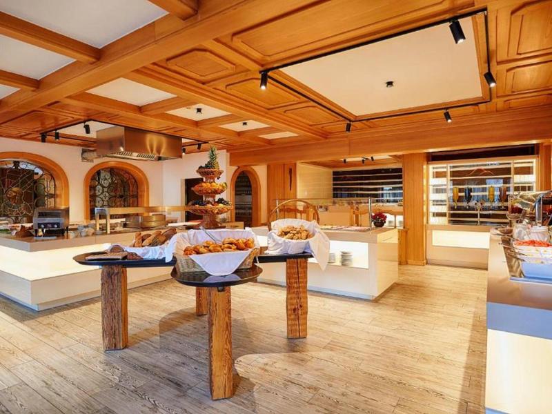 Bright shop with wooden ceiling, displays, and various baked goods on tables and shelves.