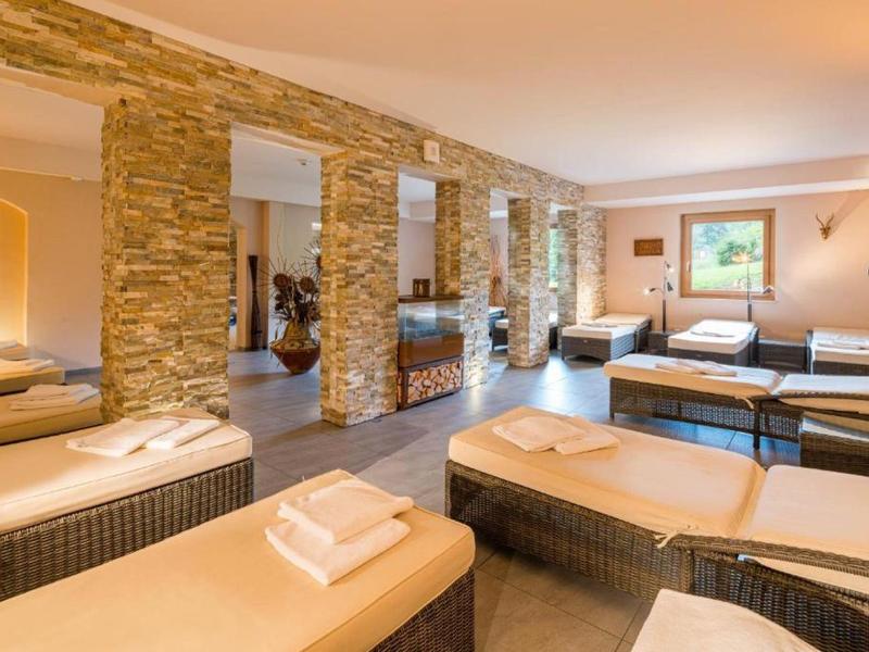 Bright wellness area with comfortable loungers, stone accent walls, and view of greenery.