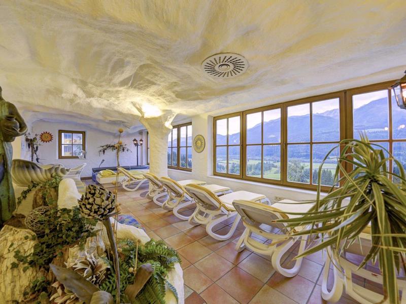 Stanza luminosa per il relax con lettini e ampie finestre con vista sulle montagne