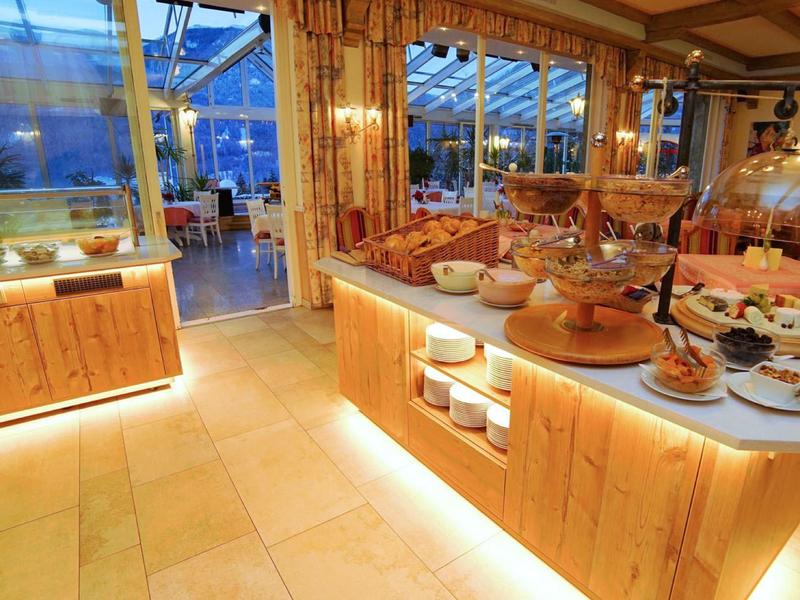 Ristorante dell'hotel luminoso con buffet e posti a sedere accoglienti alla luce serale.