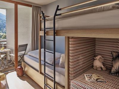 Modernes Hotelzimmer mit Etagenbett, Terrasse und Bergblick.