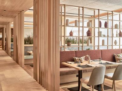 Modernes Hotelrestaurant mit Holzvertäfelungen und gemütlichen Sitzecken.