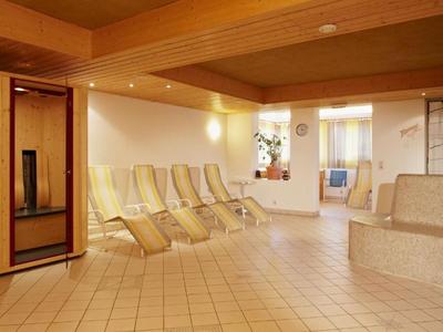 Sala de descanso con sillas reclinables y sauna en una tranquila zona de spa.