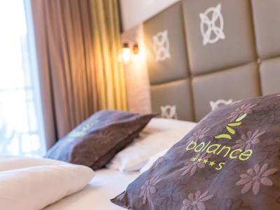 Gemütliches Hotelzimmer mit dekorativen Kissen und warmem Licht am Fenster.
