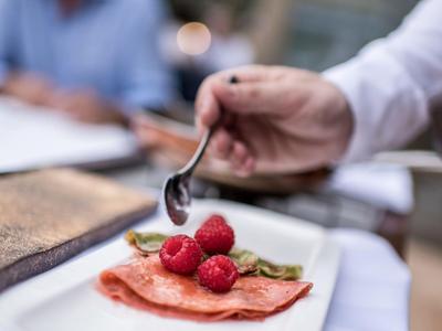 Nahaufnahme eines Tellers mit einem Dessert aus Pfannkuchen und Himbeeren in einem Restaurant.
