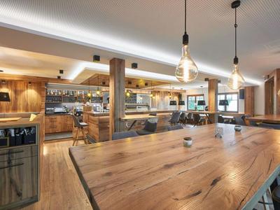 Area bar e ristorante dell'hotel moderna con mobili in legno e illuminazione accogliente.