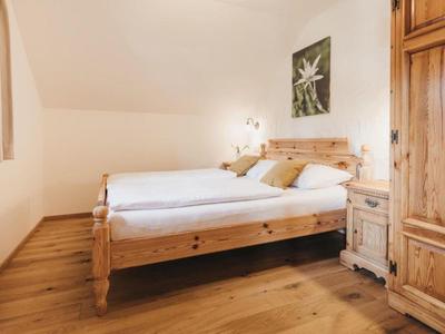 Chambre confortable avec mobilier en bois et deux lits simples près d'une fenêtre.