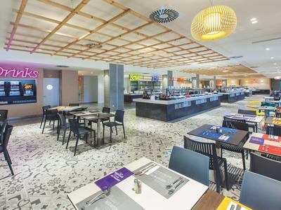 Restaurant moderne avec tables dressées et buffet dans une ambiance lumineuse.