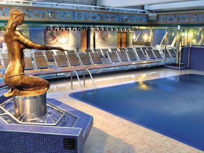 Indoor pool with bronze mermaid sculpture and lounge chairs
