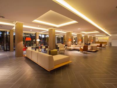 Spacious hotel lobby with modern lighting and comfortable seating areas.