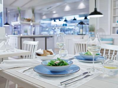 Salle à manger lumineuse avec tables dressées et salades fraîches.