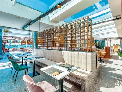 Brightly furnished restaurant area with many seats and large windows