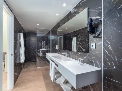 Modernes Badezimmer mit Doppelwaschbecken, großem Spiegel und schwarzer Marmorwand