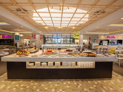 Spacious hotel buffet with a wide variety of food selections in a modern setting.