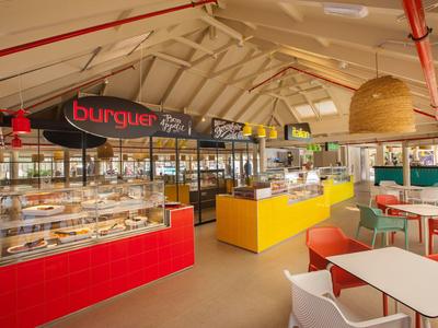 Bright, modern snack area with red and yellow counters and white seating