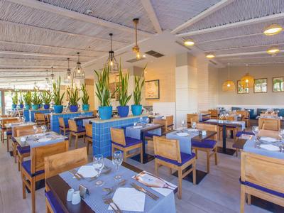 Restaurant lumineux et moderne avec mobilier en bois et accents bleus dans un hôtel.