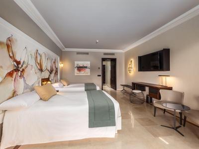 Modern hotelkamer met twee bedden, lichte vloer en stijlvolle wanddecoratie.