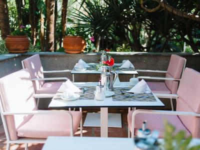 Tavolo elegante con sedute rosa e tavolo decorato in un ristorante nel giardino.