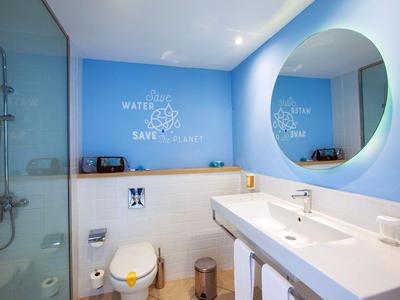 Modernes Badezimmer mit blauen Wänden, großem Spiegel und begehbarer Dusche.