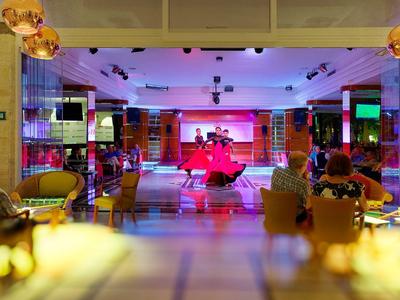 Interior of a bar with colorful lighting and guests seated at tables