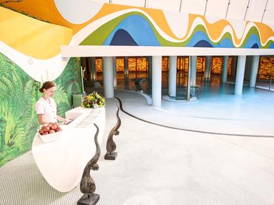 Bright reception hall with creative colorful wall design and a reception desk with decorations.