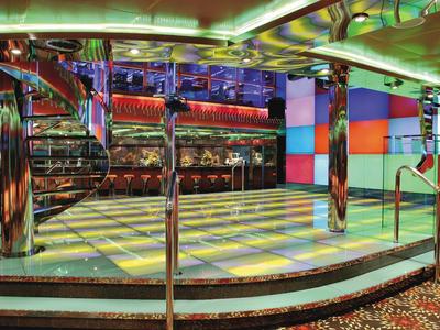 Pista da ballo colorata in una discoteca con specchi e luci sul soffitto.