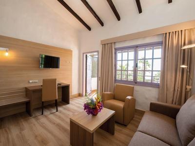Bright living room with wooden ceiling, modern lighting, and cozy seating.