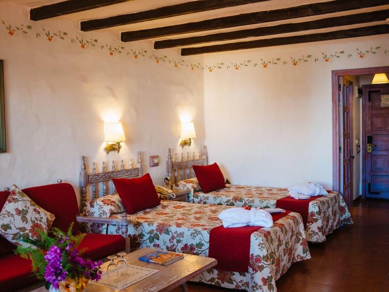 Cozy room with two single beds, vintage furniture, and wooden beam ceiling.