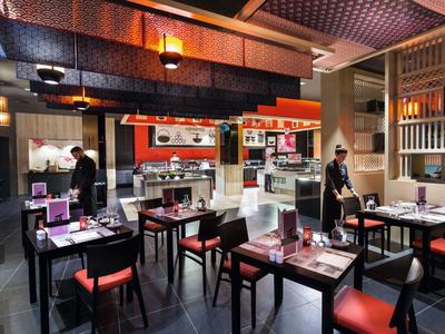 Modern restaurant with stylish tables and warm ambiance for relaxed dining.