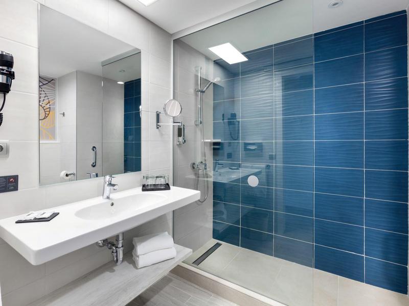 Modern bathroom with two sinks and blue tiled shower