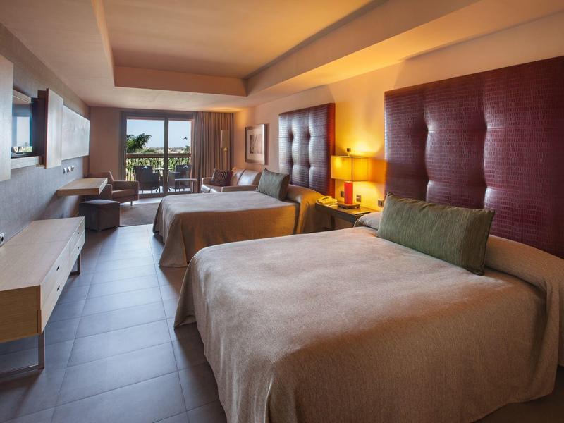 Ampia camera d'albergo con due grandi letti, design moderno e vista esterna.