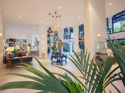 Helles und modernes Hotellobby mit Pflanzen, Sitzbereichen und großen Fenstern.