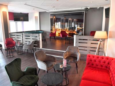 Gemütlicher Lounge-Bereich mit bunten Sesseln, Sofas und Tischen in einem modernen Hotel.