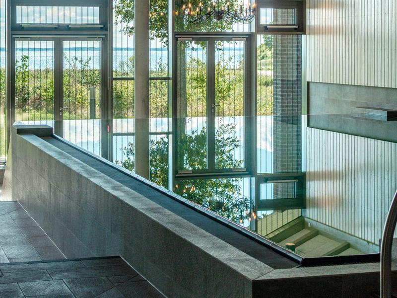 Piscine intérieure moderne avec grandes fenêtres offrant une vue sur la nature