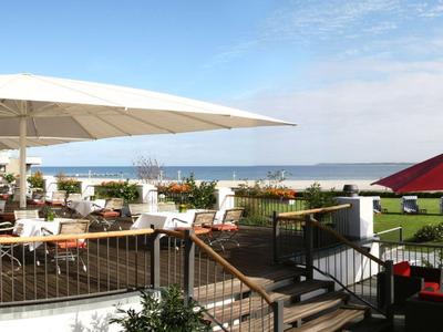 Außenterrasse mit Sitzmöbeln und Blick auf das Meer bei klarem Himmel