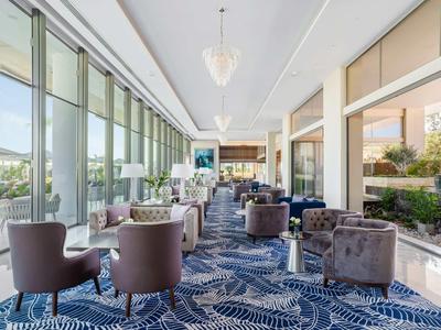 Bright lounge area with modern armchairs and large glass windows offering a view.