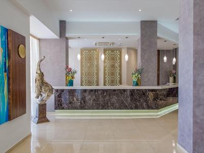 Moderner Hotellobby-Empfang mit Marmor-Theke und kunstvollen Wandpaneelen.